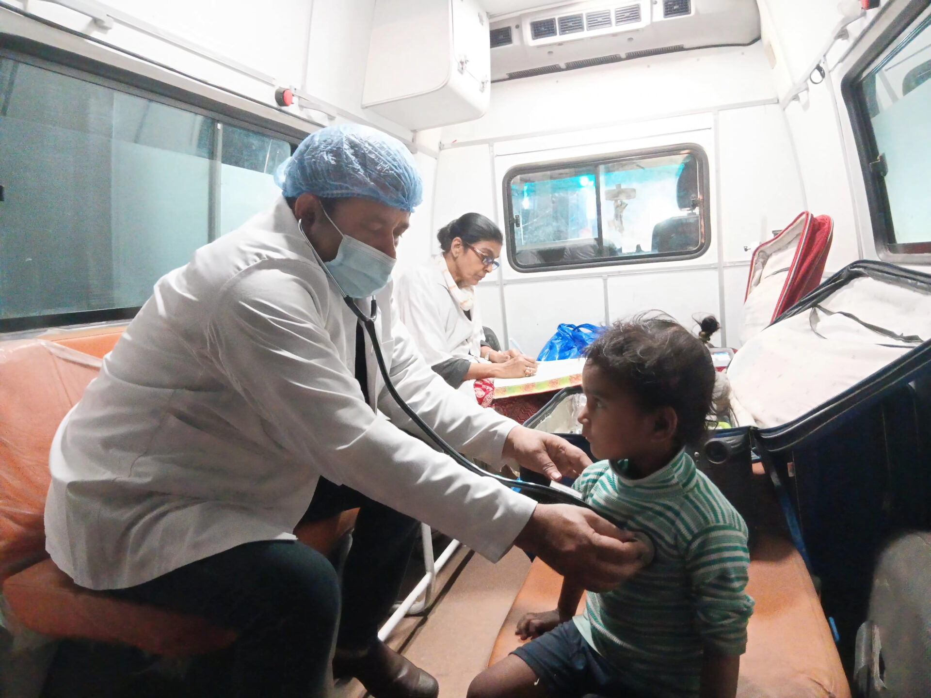 Profesional sanitario atendiendo a una niña en una unidad móvil