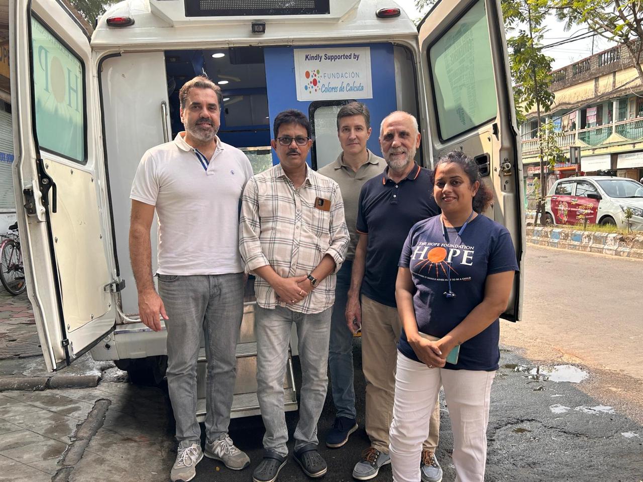 Equipo colaborador frente a la unidad móvil de salud en Calcuta